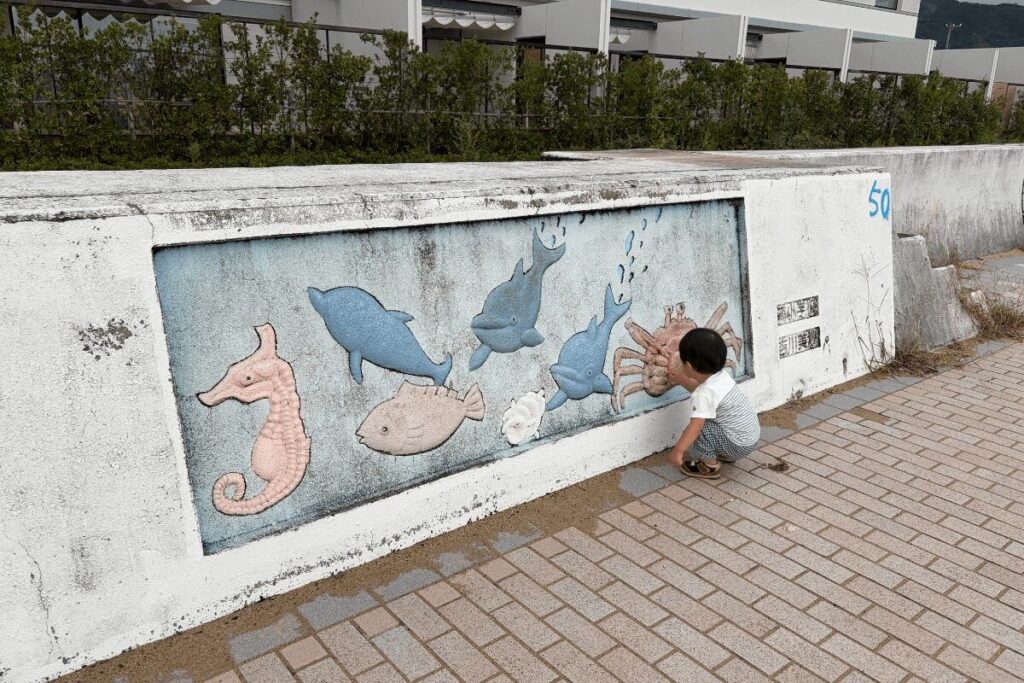 ホテル前の海岸近くで遊ぶ1歳児