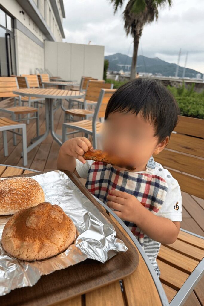 フェアフィールド淡路島東浦のテラス席で朝食を食べる1歳児