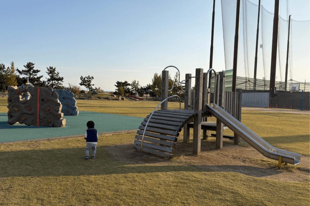 クライミングウォール横の小さなすべり台を気に入った1歳児(2025年11月)