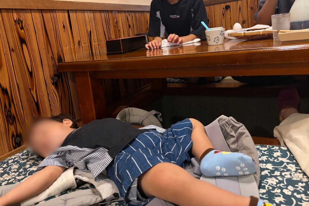 出石そば「左京」の店内でごろんと寝る1歳の次男