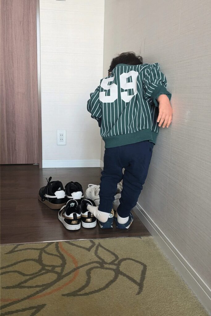 客室のフローリング部分で靴を履きお出かけ準備をする1歳次男