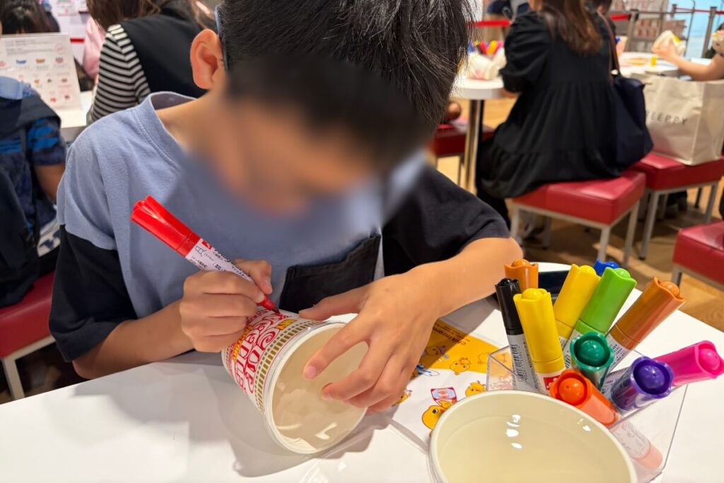 カップに絵を描く10歳の長男
